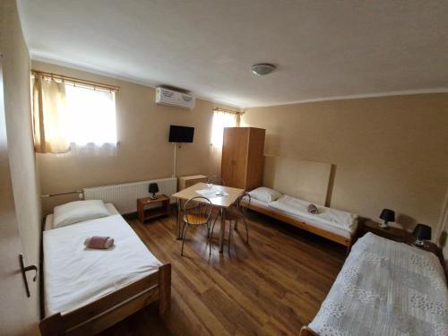 a room with two beds and a table in it at Penzion Flipper in Revúca