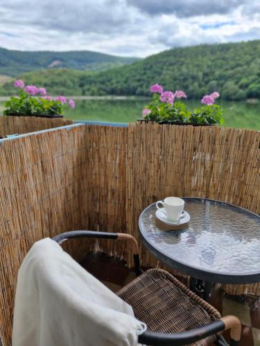 a table and chairs with a coffee cup on a balcony at Penzion Flipper in Revúca