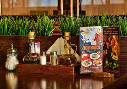 a table with two bottles of oil and a book at Отель у Ботанического Сада, в самом центре in Astana