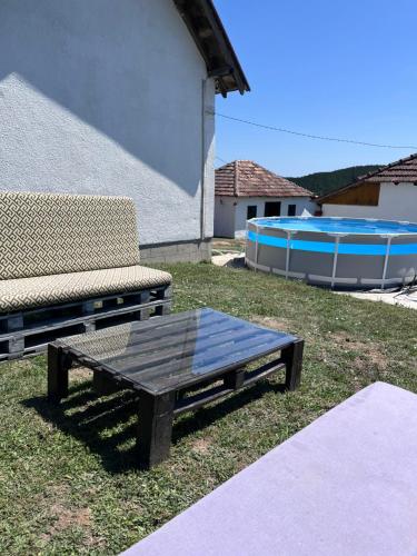 a picnic table and a bench and a swimming pool at Dedina kuća in Gornji Milanovac