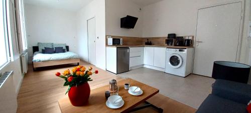 un salon avec un vase de fleurs sur une table dans l'établissement Grand studio parking-bord de Loire- hyper centre, à Orléans