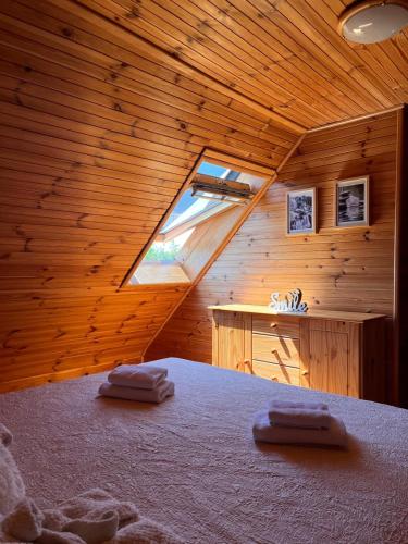 a bedroom with a bed in a wooden room at Kuća za odmor Markoci in Rakovica