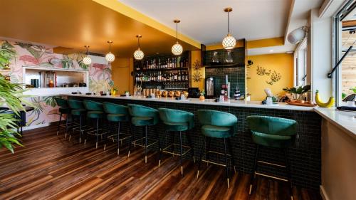 a bar with green bar stools in a restaurant at The Nevada in York