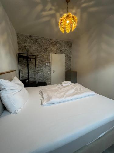 a bedroom with a white bed and a chandelier at Lisboa: Messe-/Business-/Ferienwohnung in Hilden