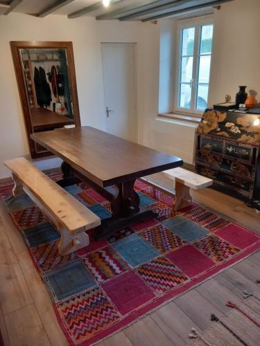 une table en bois et deux bancs dans une pièce dans l'établissement Via Lactéa, à Saint-Goussaud