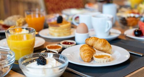 a breakfast table with eggs and croissants and orange juice at Best Western Hotel Heidehof in Hermannsburg