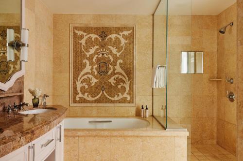 a bathroom with a tub and a glass shower at The Maybourne Beverly Hills, Maybourne in Los Angeles