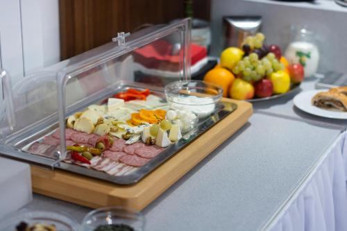 a tray of meat and vegetables on a counter with fruit at Penzion Blatnička in Blatnička