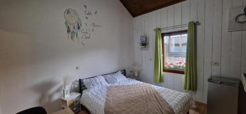a bedroom with a bed and a window at La petite suisse in Malmedy