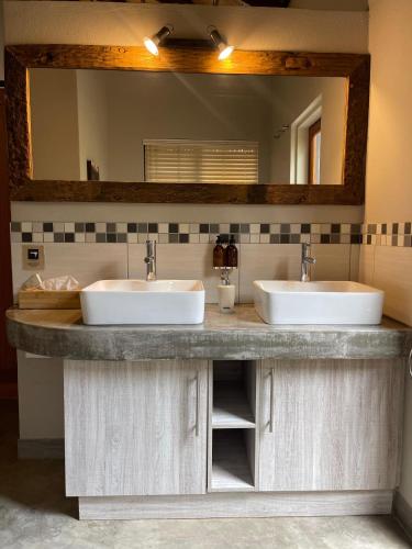 a bathroom with two sinks and a large mirror at The Baobab Bush Lodge and Villa in Hoedspruit