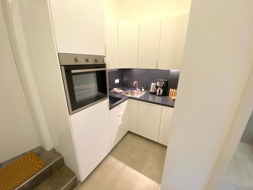 a small kitchen with a sink and a microwave at Timmenhus - neue Ferienwohnungen im historischen Bauernhaus in Timmendorfer Strand