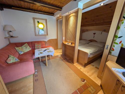 a living room with a couch and a bed at Pension Kirchleitn in Turnau