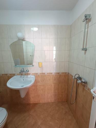 a bathroom with a sink and a toilet and a mirror at Tony Guest House in Sozopol