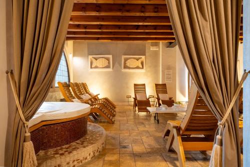 a bedroom with a bed and chairs in a room at Villa Giulia Relais & Spa in Jesolo
