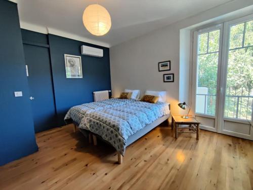 une chambre avec un lit aux murs bleus et au parquet dans l'établissement Maison de charme dans Sarlat Attention réservations et arrivées commencent exclusivement le dimanche, à Sarlat-la-Canéda