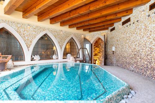 a large swimming pool in a building with a tile wall at Villa Giulia Relais & Spa in Jesolo