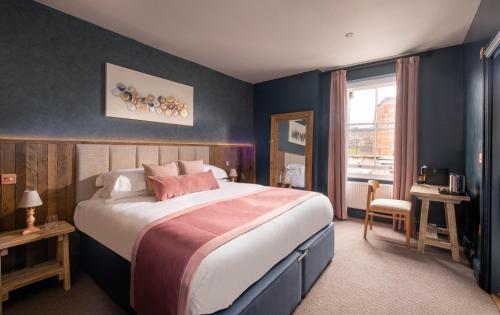 a bedroom with a large bed and a window at The Stroud Hotel in Stroud