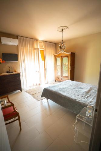 a bedroom with a bed and a chandelier at CA'du LIN - Jacuzzi e Piscina in Cisterna dʼAsti