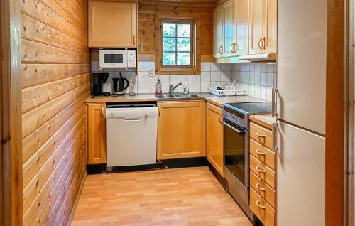 a kitchen with wooden cabinets and a white refrigerator at Älgen in Fegen