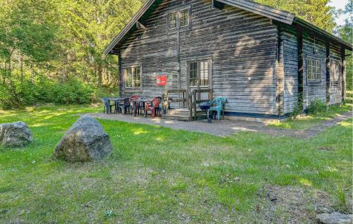 a log cabin with chairs and tables in the yard at Älgen in Fegen