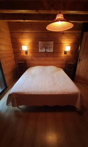 Cette chambre en bois comprend un lit blanc. dans l'établissement Chalet de Charme 100m² - Grand jardin - Gite les 4 saisons- Lac de chalain, à Marigny