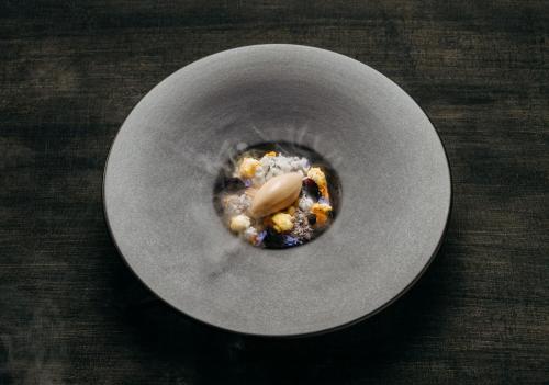 a gray bowl with food in it on a table at Hotel PURS in Andernach
