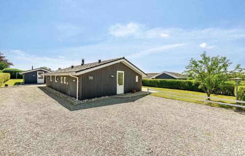 a house with a garage in a gravel driveway at Holiday Home Råde Strandpark Haderslev Xii in Årøsund