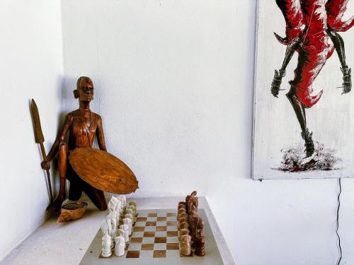 a statue of a man sitting next to a chessboard at Dream House in Watamu
