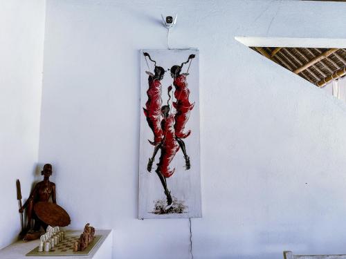 a painting of two people hanging on a wall at Dream House in Watamu