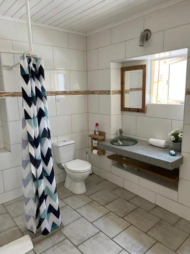 a bathroom with a toilet and a sink and a mirror at Mustique Suites Curacao in Willemstad