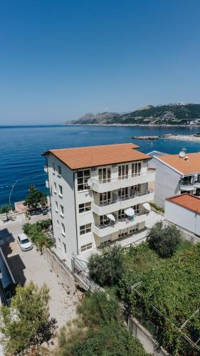 an apartment building with the ocean in the background at MonteCasa Seaview Rooms in Dobra Voda