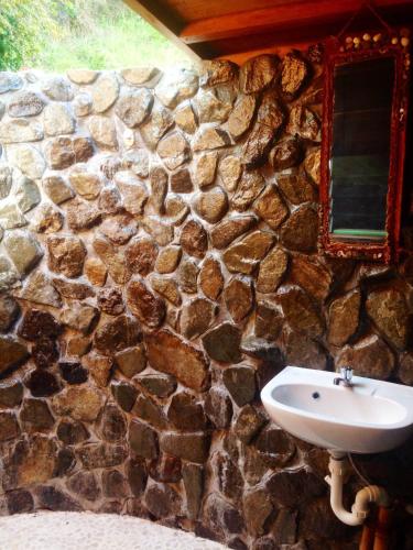a stone wall with a sink and a mirror at Naveria Heights Lodge in Savusavu