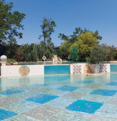 a swimming pool with blue tiles in the water at Agriturismo Cascina Madonnina in Pregnana Milanese