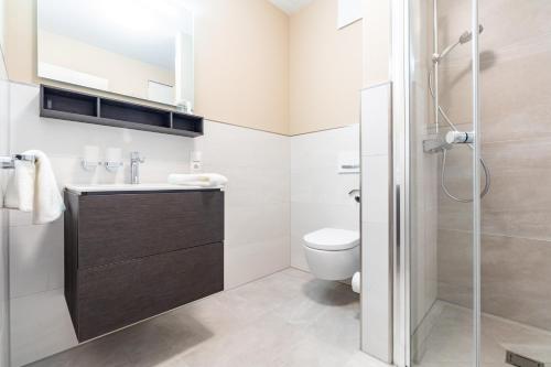 a bathroom with a toilet and a sink and a shower at Ostsee Apartmenthotel in Graal-Müritz