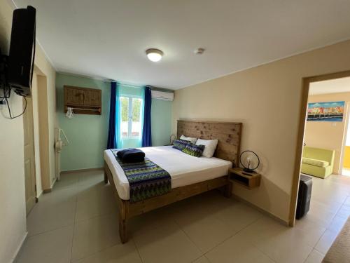 a bedroom with a bed and a television in it at Mustique Suites Curacao in Willemstad