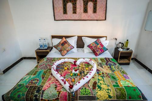 a bed with a heart made out of pillows at Rose Merry Guesthouse in Bikaner