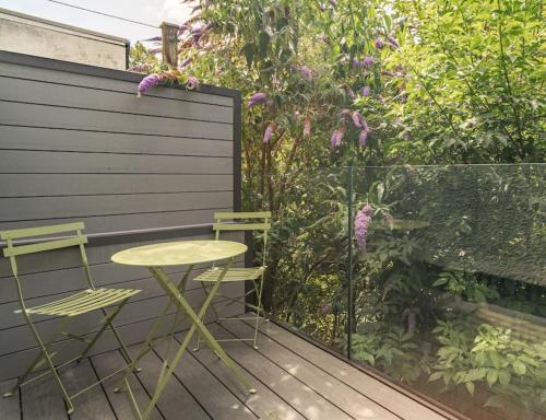 a table and two chairs on a wooden deck at Cottage Cwtch in Pont-Nedd-Fechan