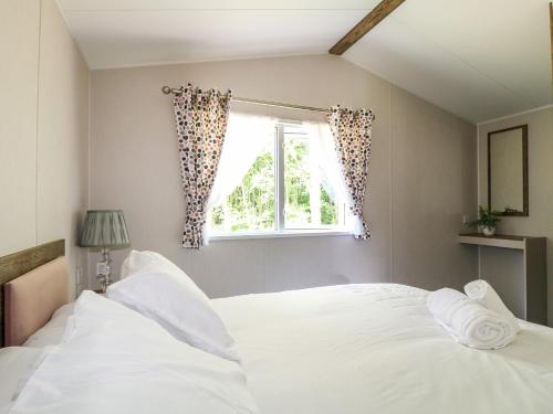 a bedroom with a white bed and a window at Swan Lodge in Coalville