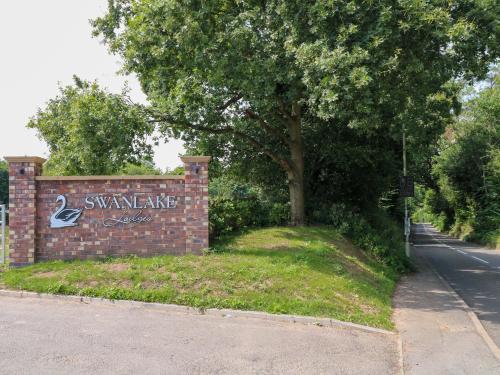 a sign for a swanane sign on a brick wall at Swan Lodge in Coalville