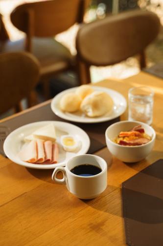 a table with plates of breakfast food and a cup of coffee at Strassen Hotel in Goiânia
