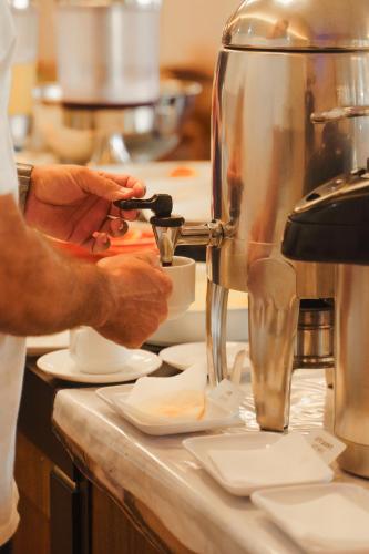 a person is preparing food in a kitchen at Strassen Hotel in Goiânia