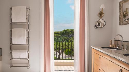a bathroom with a door leading to a balcony at Airelles Château de la Messardière in Saint-Tropez