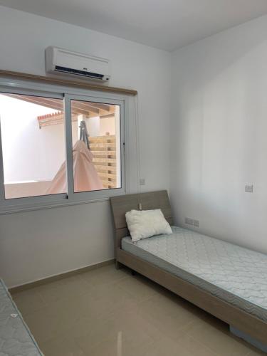 a bed in a room with a window at Valentine Family Villa in Kiti