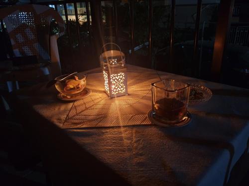 a table with a candle and two glasses on it at Lovely maison house 50m from the beach at Nea Flogita in Flogita