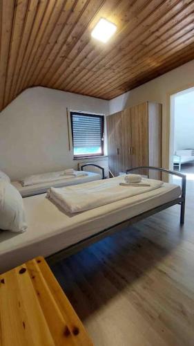 a bedroom with two beds in a room with a wooden ceiling at WA122 - Große Monteurwohnung Übergangswohnung in Wackersdorf
