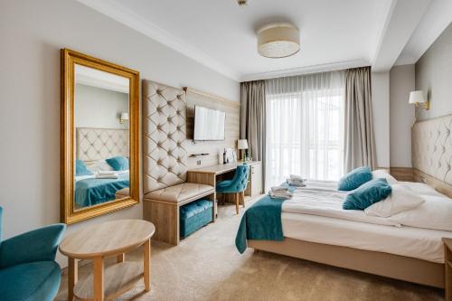 a hotel room with a bed and a mirror at Villa Meduza in Kołobrzeg