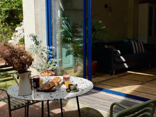 une table avec de la nourriture dessus sur une terrasse dans l'établissement la Maison sous les Arbres - Duplex, jardin et spa, à Pocé-sur-Cisse