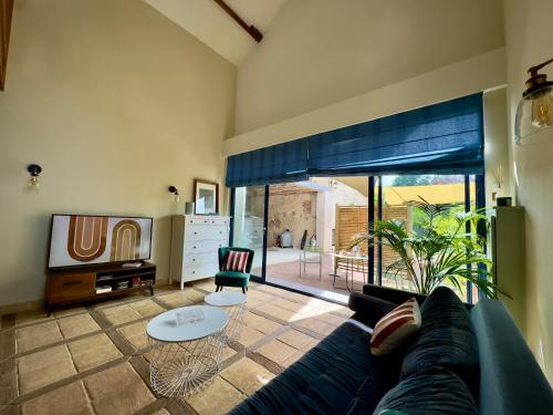 un salon avec un canapé et une télévision dans l'établissement la Maison sous les Arbres - Duplex, jardin et spa, à Pocé-sur-Cisse