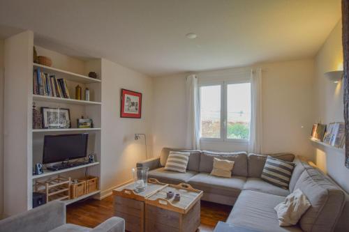 a living room with a couch and a tv at Domaine d'Essendiéras in Saint-Médard-dʼExcideuil