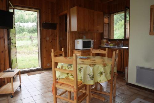 une cuisine avec une table et des chaises dans une pièce dans l'établissement Small duplex chalet with garden, à Saint-Chaffrey